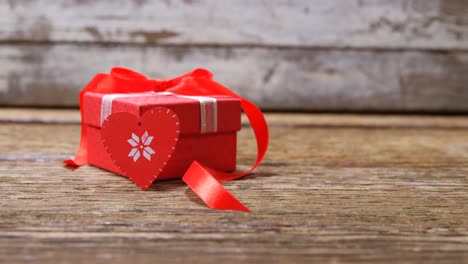 corazón rojo y caja de regalo en superficie de madera 4k
