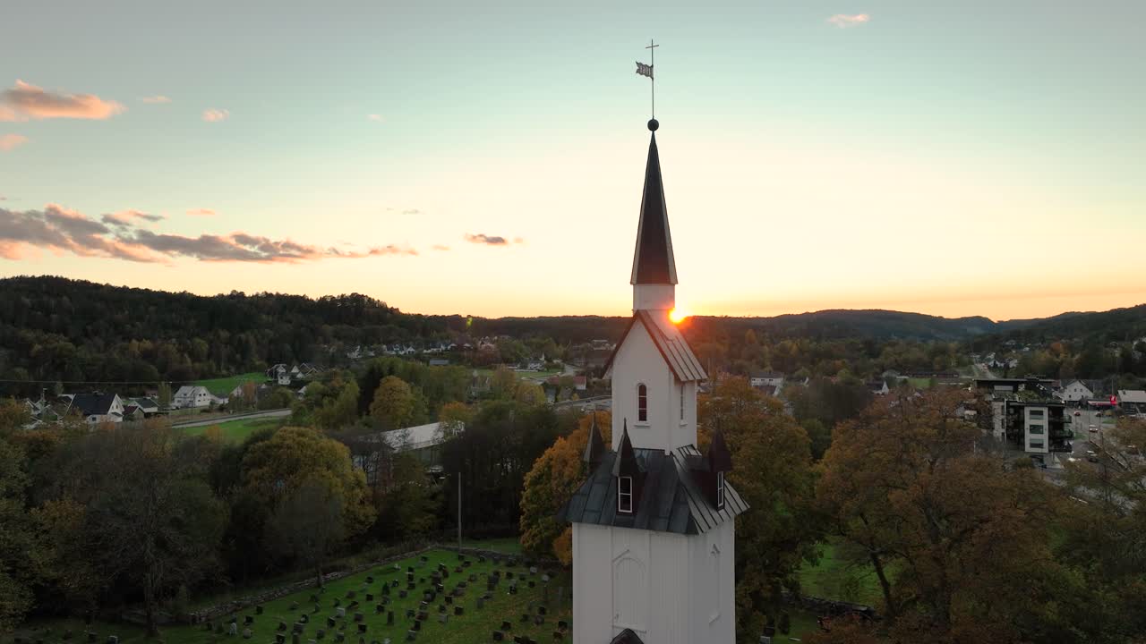 Drone elegantly circles church tower, showcasing architectural beauty and surroundings.