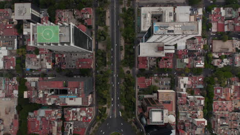 Vista-Aérea-De-Pájaros-Vista-De-Arriba-Hacia-Abajo-Del-Tráfico-En-Una-Calle-Ancha-De-La-Ciudad.-Cruce-De-Rotonda-De-Varios-Carriles-Desde-Drones-Volando-Hacia-Adelante.-Ciudad-De-México,-México.