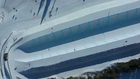 drone aerial copper mountain winter ski snowboard resort half pipe training practice tricks competition colorado early morning sunlight fresh snow unique birds eye cinematic looking down follow pan 4k