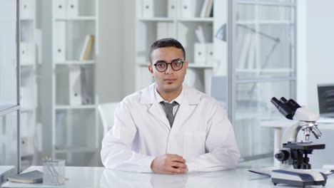 científico del medio oriente usando una pantalla táctil de ar invisible en el laboratorio