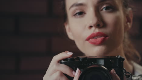 Young-woman-photographer-using-photo-camera-for-take-picture-in-studio