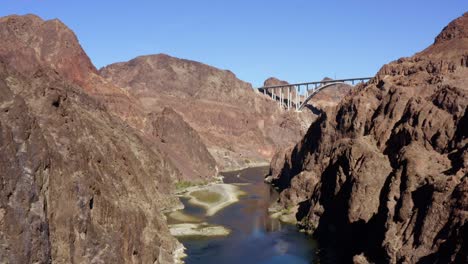 aerial view over the colorado river in middle of cliffs of kingman, nevada, usa - tracking, drone shot