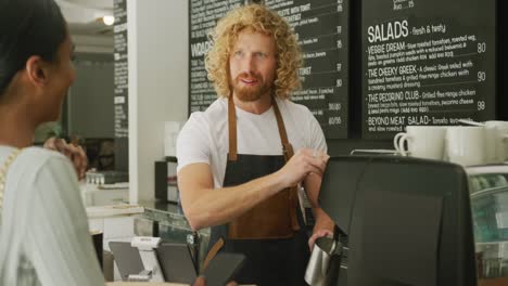 Fröhliche,-Vielfältige-Frau,-Die-Kaffee-Kauft-Und-Mit-Einem-Männlichen-Barista-Im-Café-Spricht