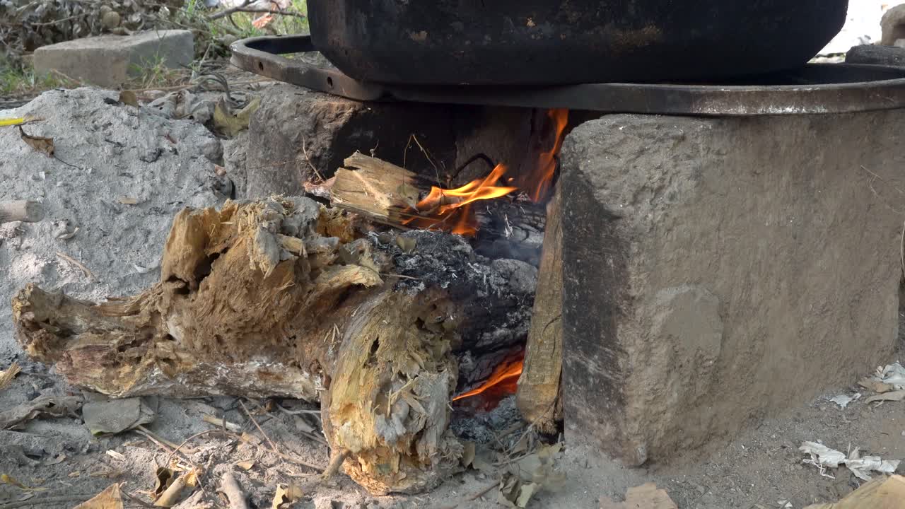 Cooking Over an Open Fire in a Rustic Setting