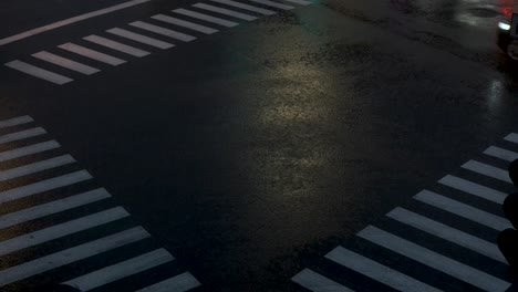 Crossroad-under-heavy-rain-with-cars-and-pedestrian-passing-by