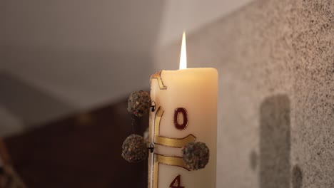 una vela encendida con símbolos religiosos, creando una atmósfera serena y espiritual, evocando la paz y la reflexión