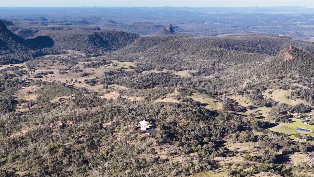 Ampia ripresa aerea di montagne aspre e foreste di eucalipto nel Parco Nazionale Warrumbungle, Australia.