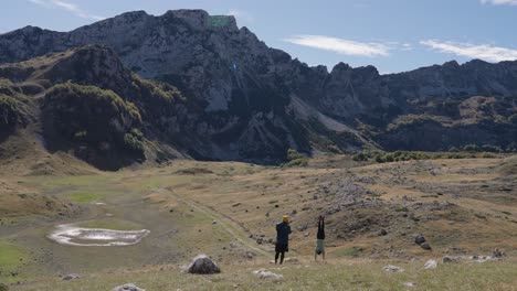 two people in durmitor mountains doing a handstand on a sunny day, static shot