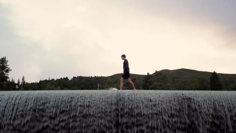 man walking on top of a dam in norway, europe 4k