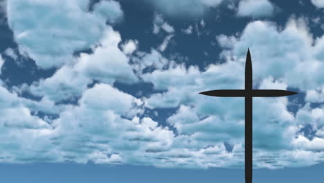 silhouette of cross against blue sky with scattered white clouds in background