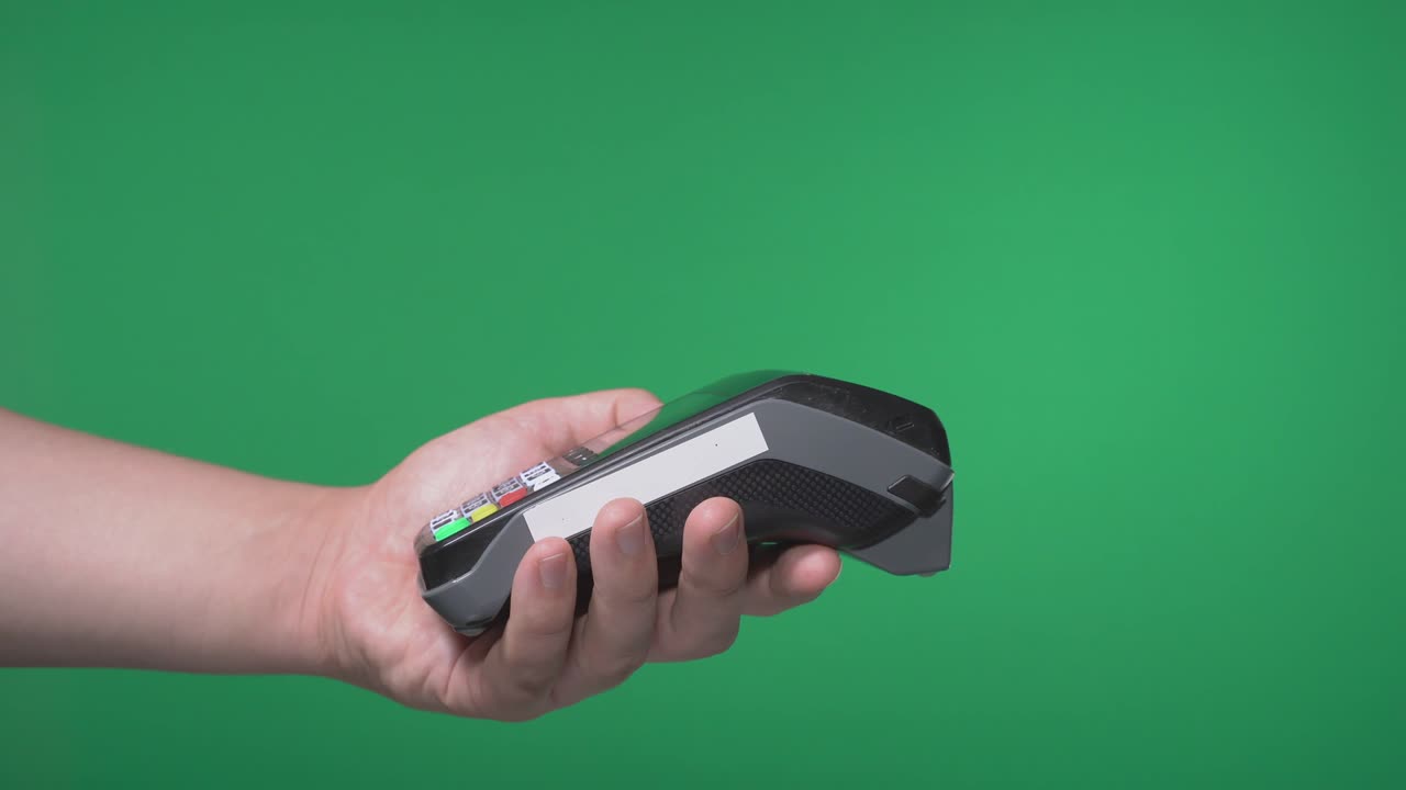 Close up male hold in hand wireless modern bank payment terminal to process acquire credit clock payments isolated on green screen. Copy space mock up advertising, girl pay