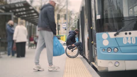 person with a physical disability enters public transport with an accessible ramp