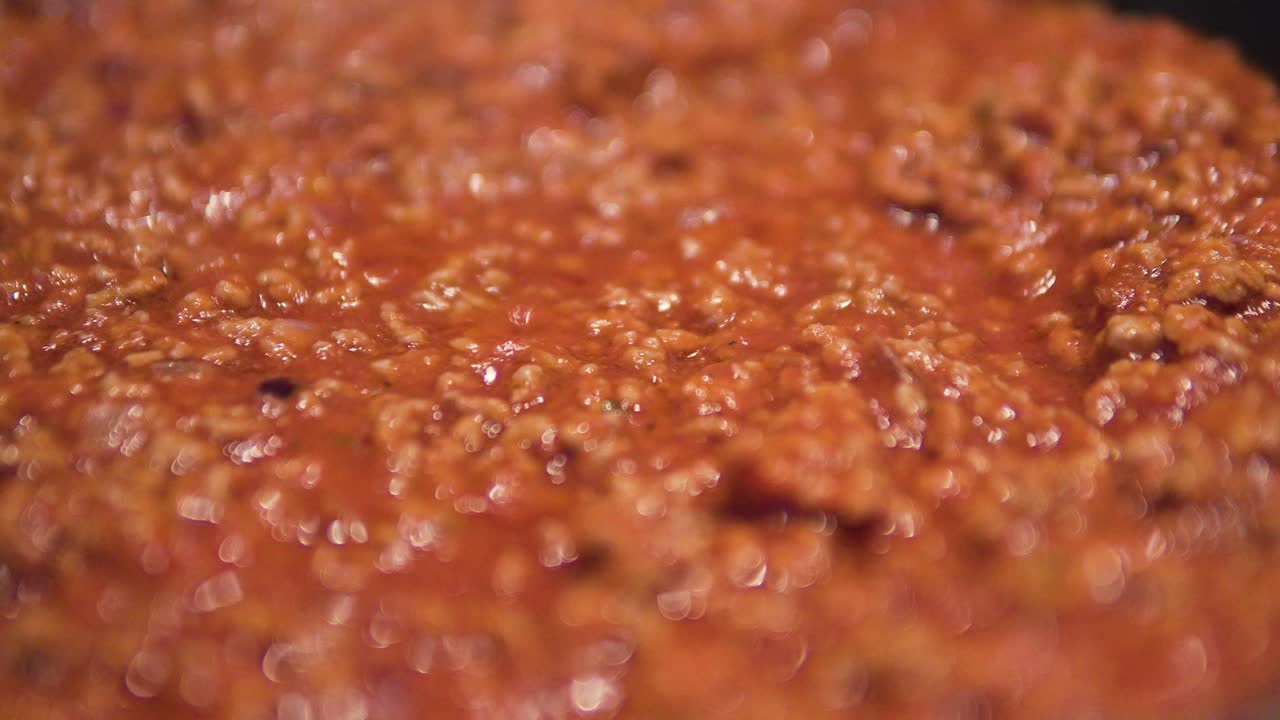 cocinar salsa boloñesa cerca de carne picada hirviendo en una sartén