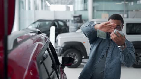 Dark-skinned-man-scattering-money-in-a-car-dealership