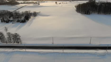 Imágenes-De-Drones-De-4k-Que-Se-Desplazan-Para-Revelar-Campos-Nevados,-Carreteras-Y-Pueblos-En-La-Ciudad-Rural-De-Esquí-De-Niseko,-Japón,-Durante-La-Puesta-De-Sol-Y-La-Hora-Dorada