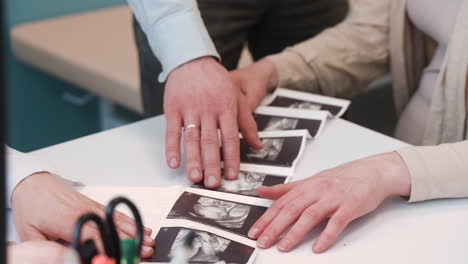 close up view of gynecologist showing ultrasound images to her pregnant patient in medical consultation