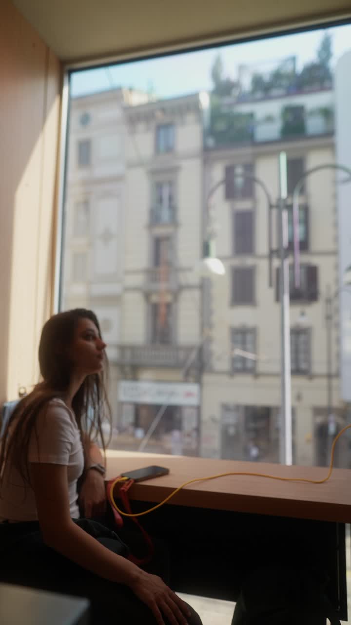 Woman working at a window seat in a cafe