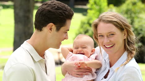 Padres-Felices-Con-Su-Niña-En-El-Parque