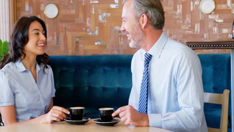 woman and businessman interacting with each other while having coffee