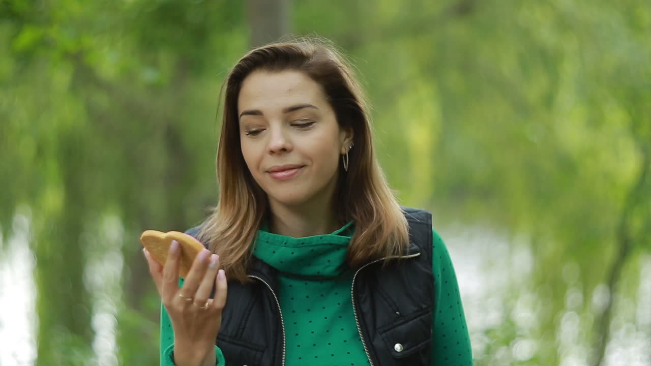Giovane donna con biscotti. Giovane donna sorridente con biscotti tra le mani