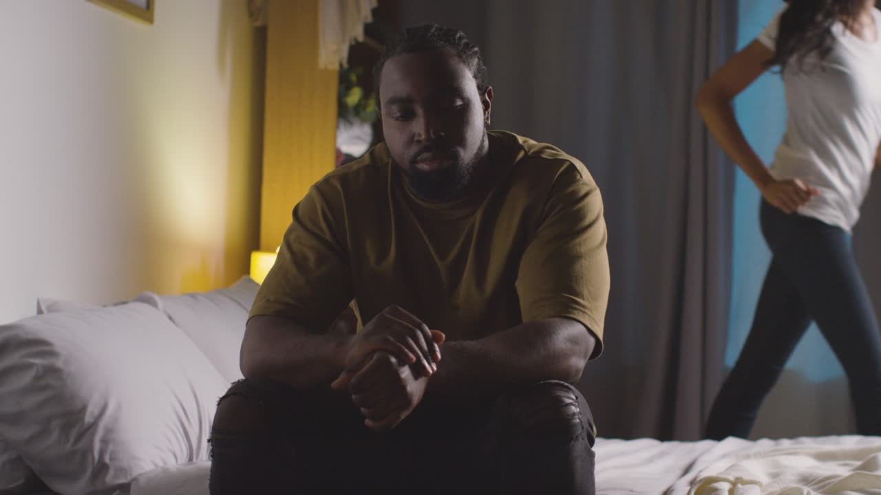 Couple At Home Sitting On Bed At Night Having Argument 5