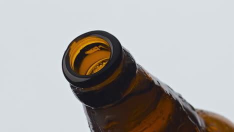 abertura de botella de cerveza de vidrio de primer plano. sidra carbonatada espumosa que se vierte desde el frasco