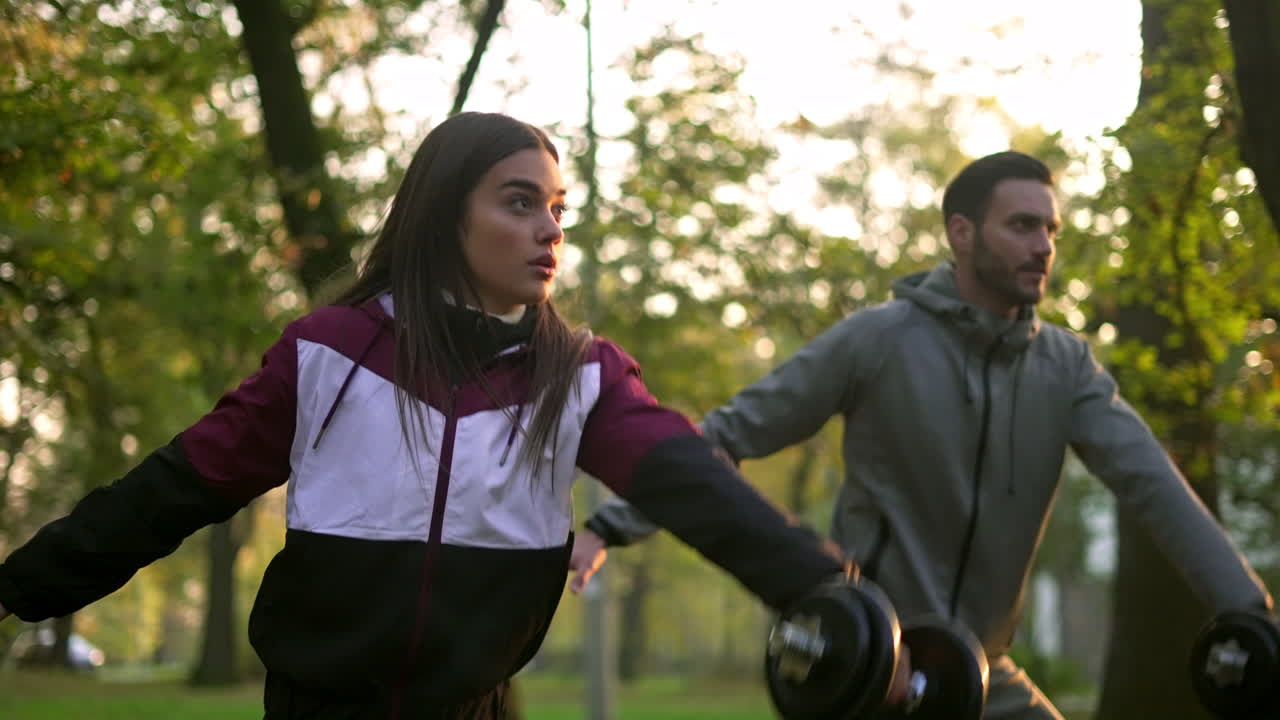 pareja haciendo ejercicio con pesas al aire libre