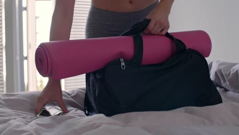 mujer joven empacando su bolsa de gimnasio para todo el día