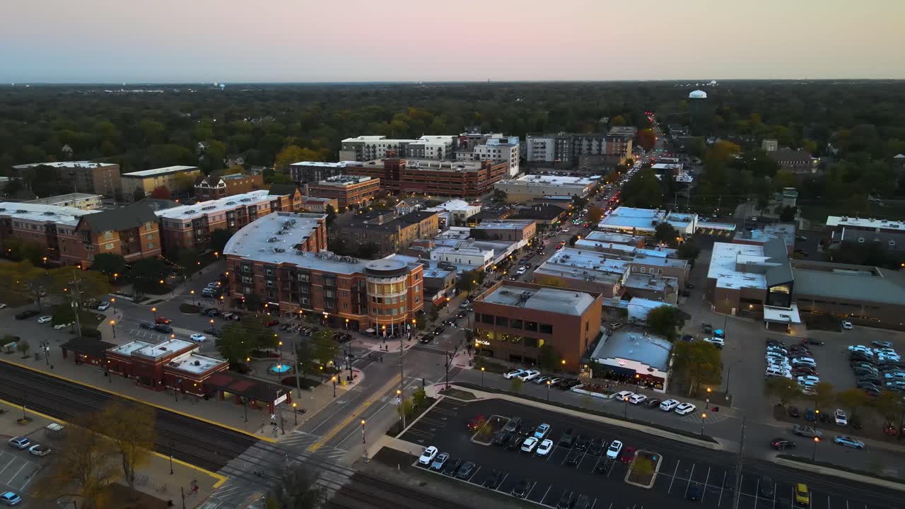 Aerial capture of Downers Grove Illinois at dusk featuring illuminated streets and urban landscape. Orbit Right Dusk S