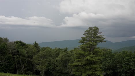 Single-point-panoramic-shot-left-to-right,-capturing-a-cloudy-sky-over-forested-mountainous-area