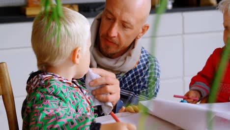 father wiping his son mouth with napkin cloth at home 4k