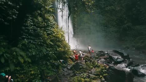 bali, spring 2020 in 1080 60p, daytime, cinematic drone flight long slow motion backward flight from waterfall over a small group of tourists