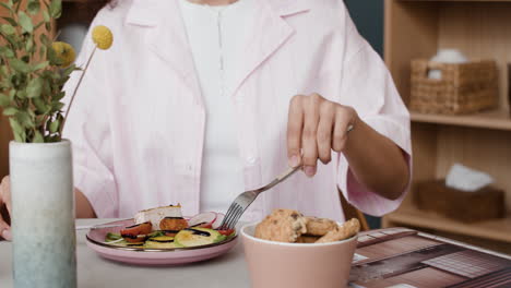 a woman eating and tasting food indoors