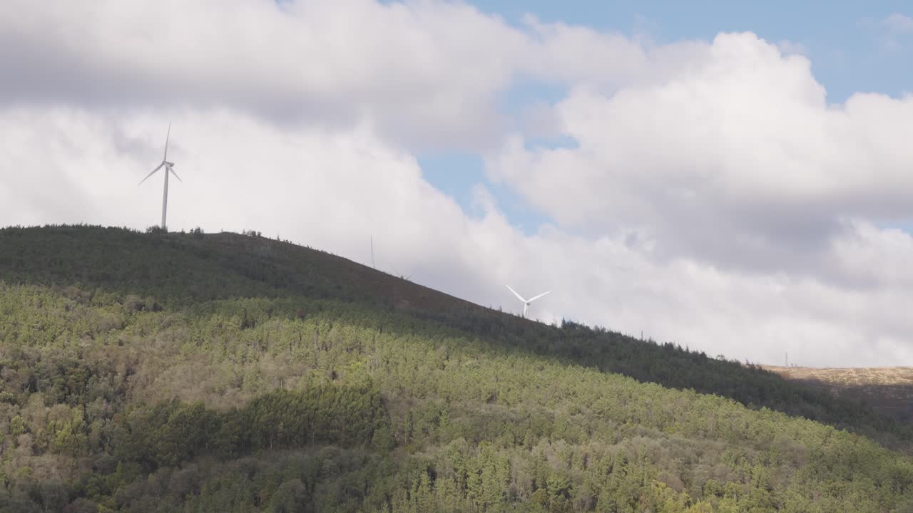 Time-lapse of large windmills spinning on a partly cloudy day