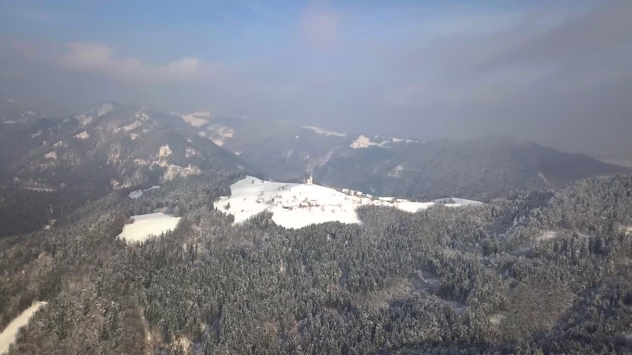 겨울 동안 중앙 슬로베니아의 언덕 꼭대기에 있는 그림 같은 스베티 토마즈 교회