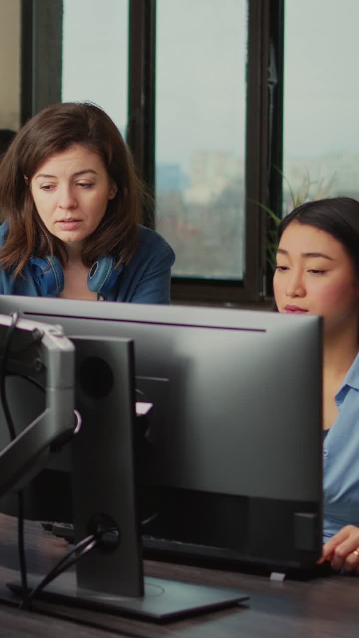 Vertical video: Creative people analyzing machine industry software on computer