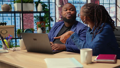 young couple doing teamwork and multitasking on laptop at desk