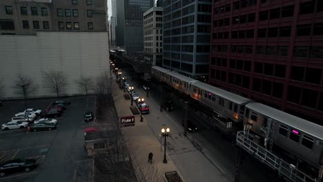 subway train and cars passing through downtown urban jungle at dusk