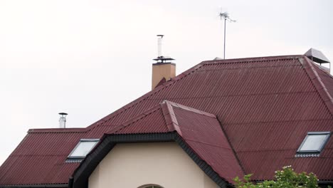 house exterior with red metal roof and chimneys