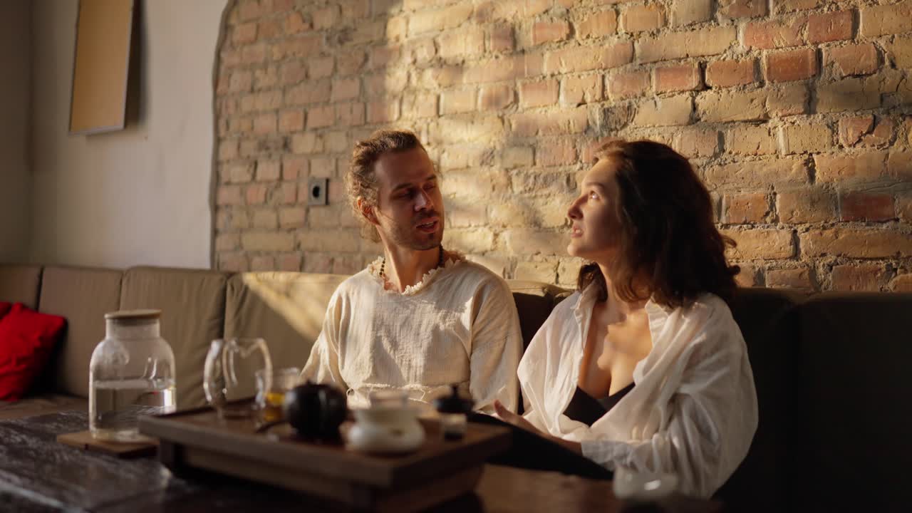 커플 이 카페 에서 차 의식 을 하는 동안 앉아서 대화 하고 있다