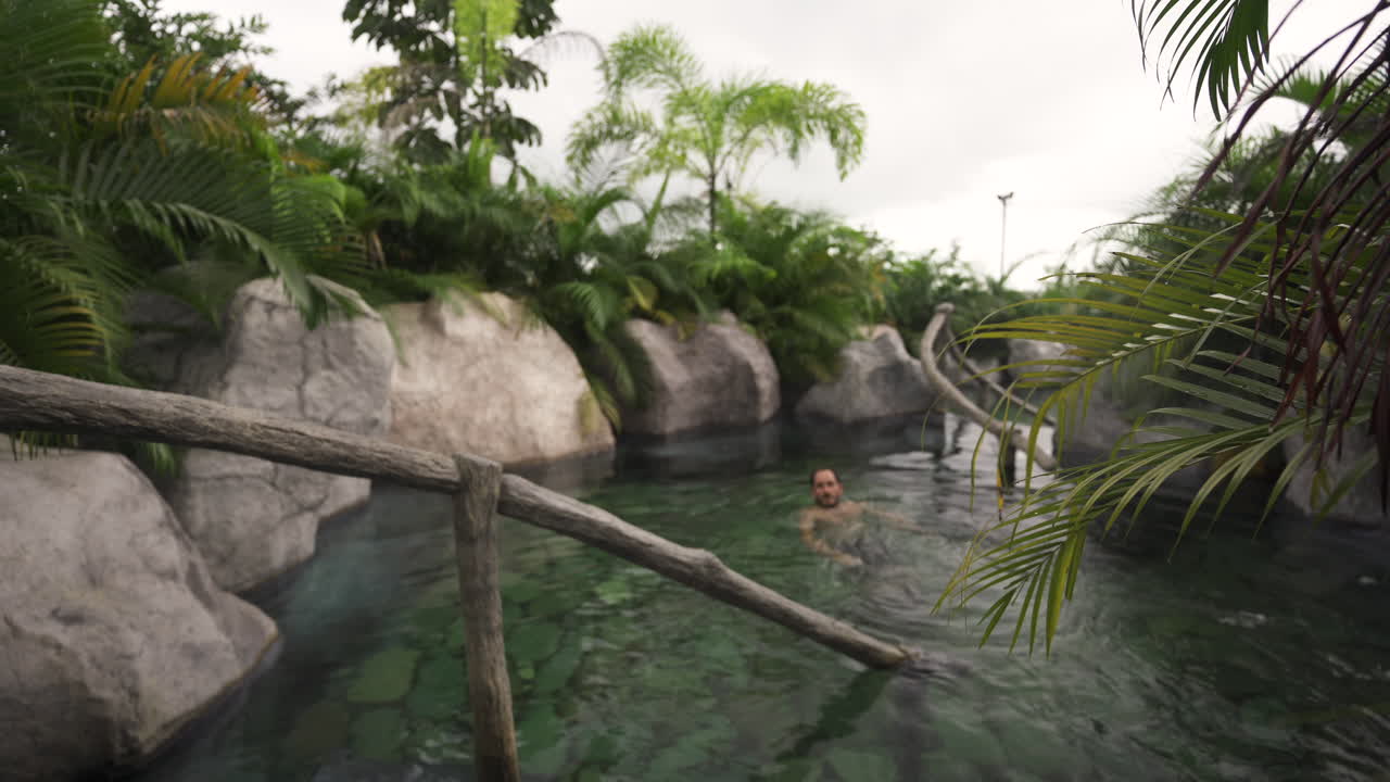 aguas termales monteverde 온천 코스타리카 백인 관광객은 아름다운 녹색 자연 경관 낙원의 자연 수영장에 입장합니다.