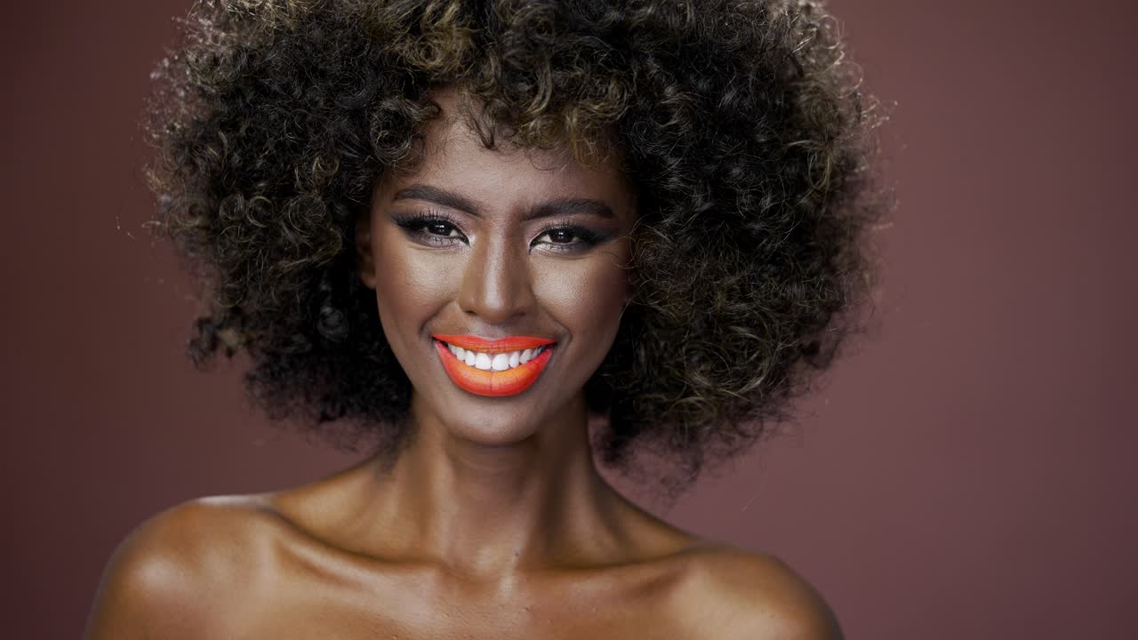 прекрасная женщина с афро и оранжевыми губами.