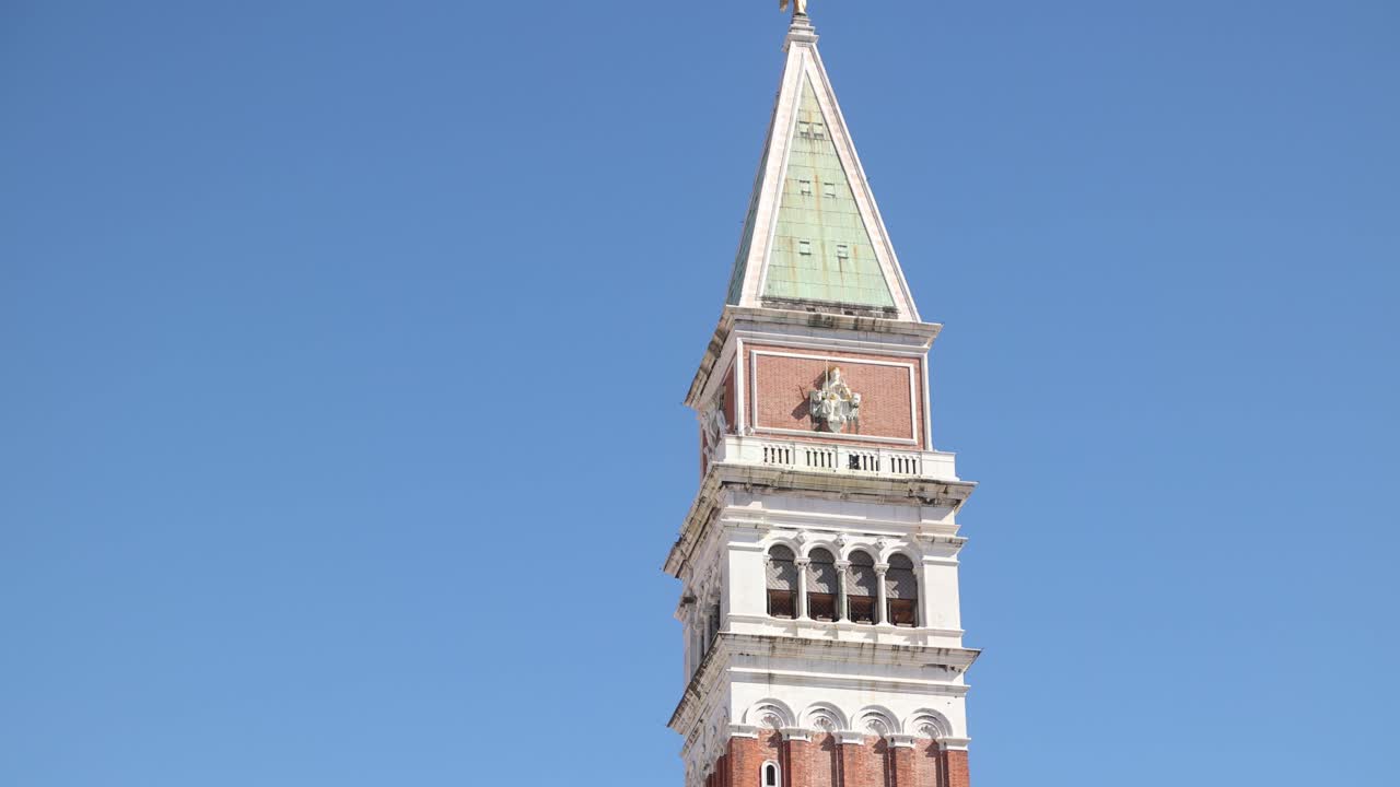 Close-up of St. Mark's Campanile reaching into a clear blue sky background in Venice.