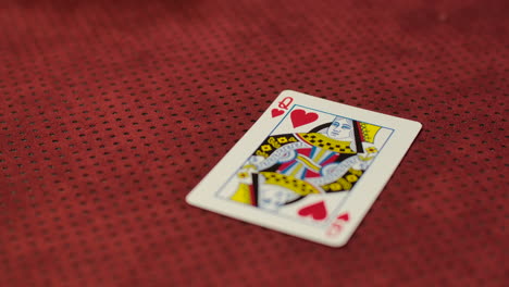 slow motion closeup of a card dealer revealing a queen of arts on the game table