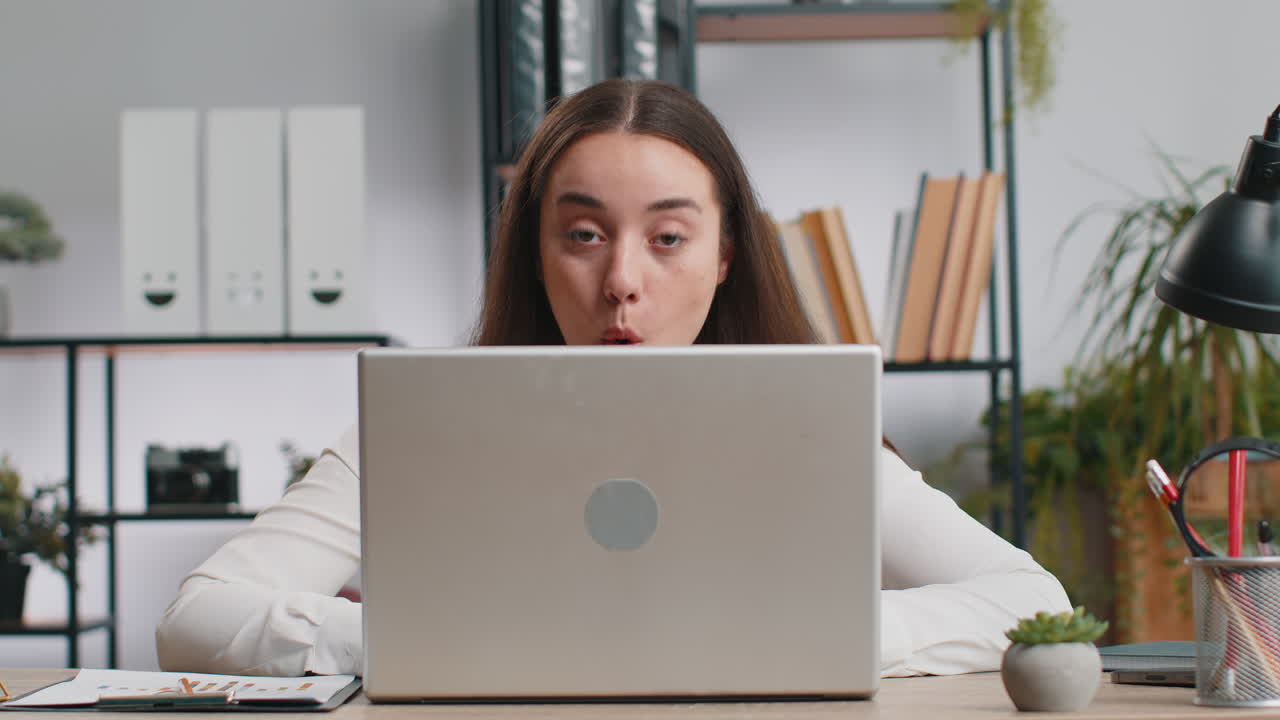 Office businesswoman hiding behind laptop computer making funny silly face fooling around disrespect