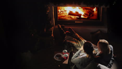 young couple relaxing at home by the fireplace comfortable warm home concept