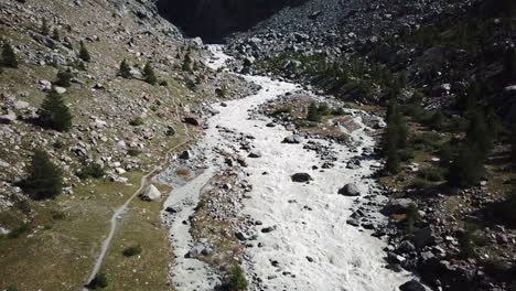 vista aérea de drones de un lecho de río de montaña, el agua proviene del derretimiento del glaciar, paisaje de los alpes suizos, agua fangosa con corriente fuerte