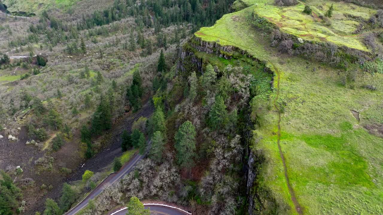 Un'ampia ripresa aerea panoramica con drone DJI che rivela una strada ventosa accanto a un'alta scogliera vicino al Rowena Crest Viewpoint nella Columbia River Gorge National Scenic Area a Mosier, Oregon, prima dell'incendio