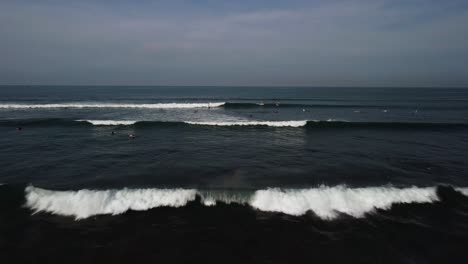 Tiro-Aéreo-De-Empuje-Hacia-Adelante-Surfista-En-El-Océano-Espere-En-La-Ola-Bali